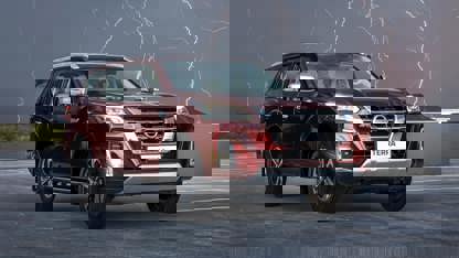 Red Nissan Terra in open field with lighting in background