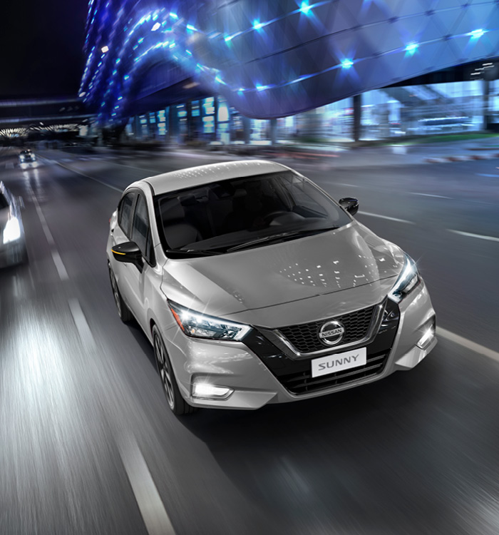 Silver Nissan Sunny driving on road at night
